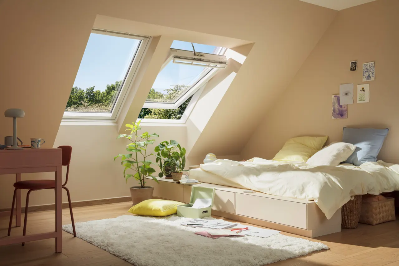 Helles Dachzimmer mit zwei Velux-Dachfenstern, eines davon geöffnet