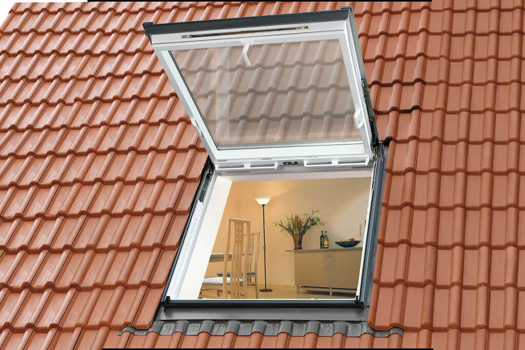 Geöffnetes Velux-Klapp-Schwingfenster in einem roten Ziegeldach